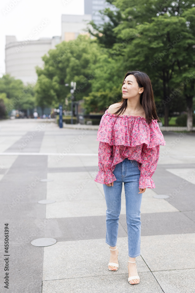 Portrait of young asian woman wearing stylish casual clothing and walking outdoor in city. Happy stylish woman with smiley face enjoys life