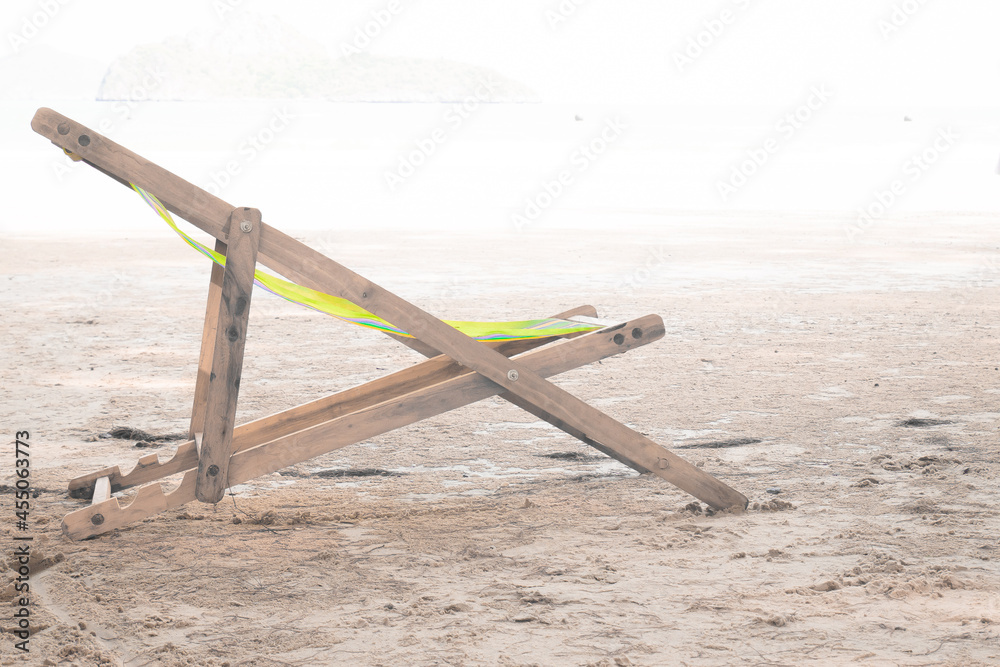 Fototapeta premium Wooden chaise lounge on a soft white background on beach