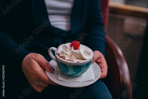 girl holding coffee with cherry on top