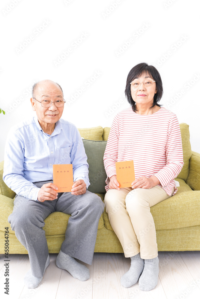 年金手帳を持つ高齢の夫婦 年金手帳を持つ高齢の夫婦