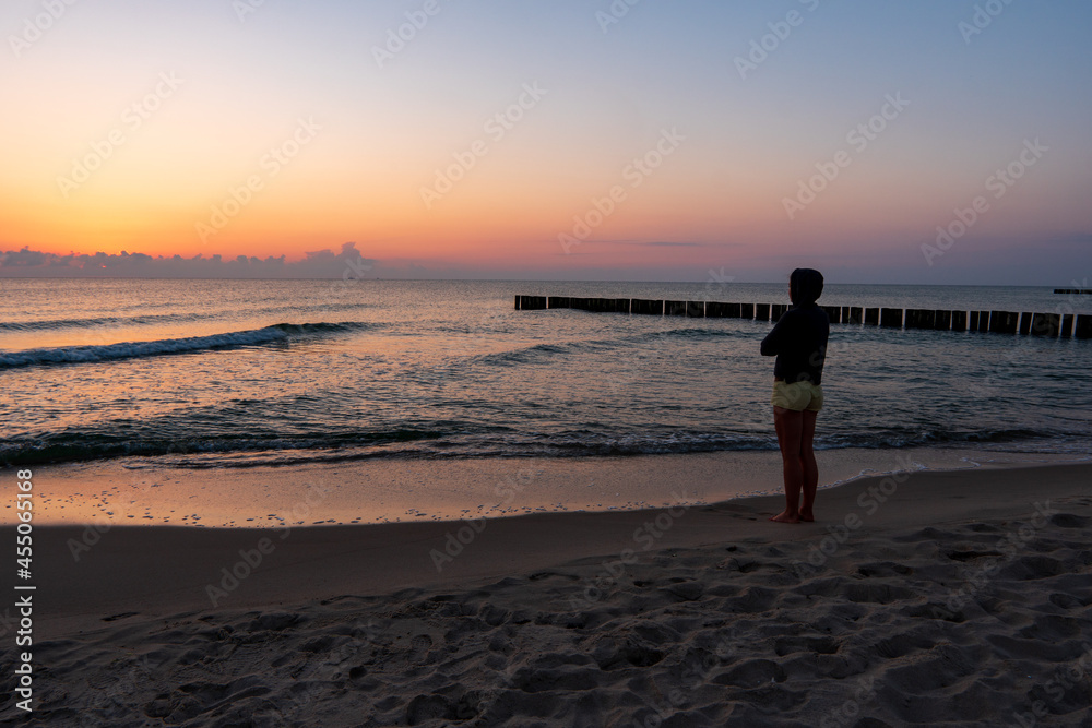 Woman walking on tropical beach at sunrise Woman walking on tropical beach at sunrise