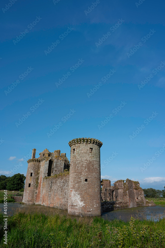 Vertical orientation of Caerlaverock Castle, Dumfries and Galloway, Scotland, in sunshine with blue sky, no people. Lots of copy space above in sky area.