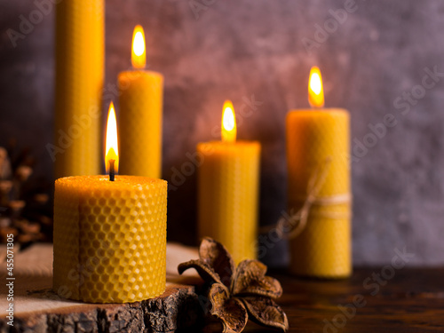 Quadro em tela A handmade of natural wax with texture of honeycomb bees candles burns on the table, an unusual element of the interior