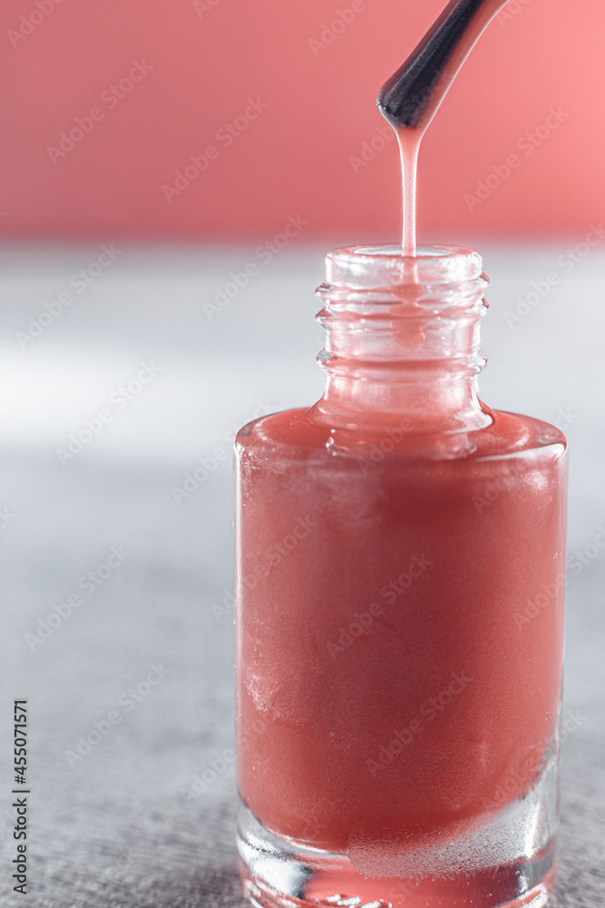 pink nail polish up close. from the brush, the varnish drips into a jar in macro pink nail polish up close. from the brush, the varnish drips into a jar in macro