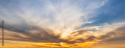 Panorama view of sunrise behind clouds in the golden and blue sky, natural scenery