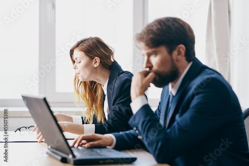 business man and woman sitting in front of a laptop teamwork internet officials