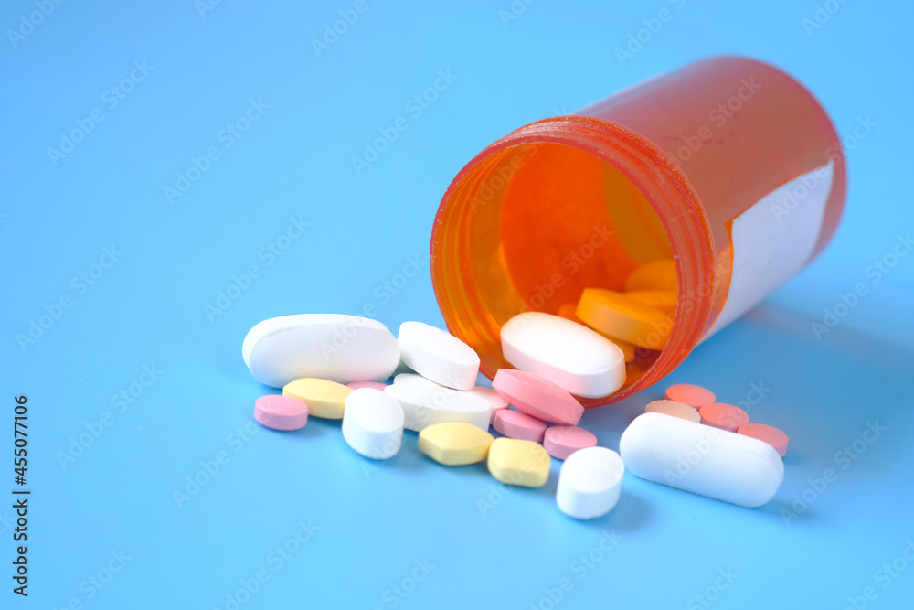 Close up of many colorful pills and capsules on blue background Close up of many colorful pills and capsules on blue background