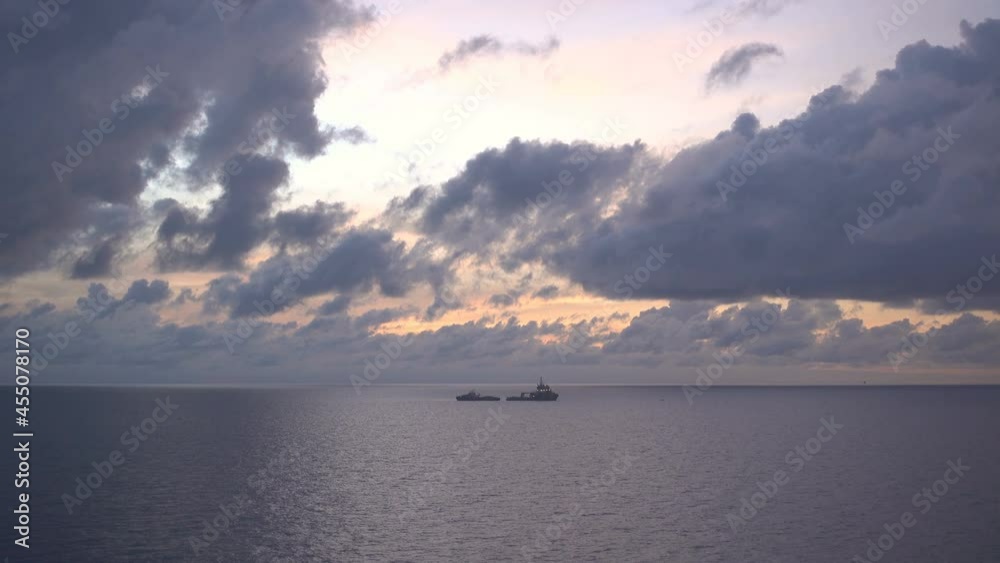 Two Boat Silhouettes while refill fuel at Sunset Over Sea.Orange Red Color Sunrise dramatic sky adn clouds On Horizon.
Two Boat Silhouettes while refill fuel at Sunset Over Sea.Orange Red Color Sunrise dramatic sky adn clouds On Horizon.