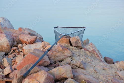 landing net of a fisherman on the rocky shore of the lake Balaton in Hungary