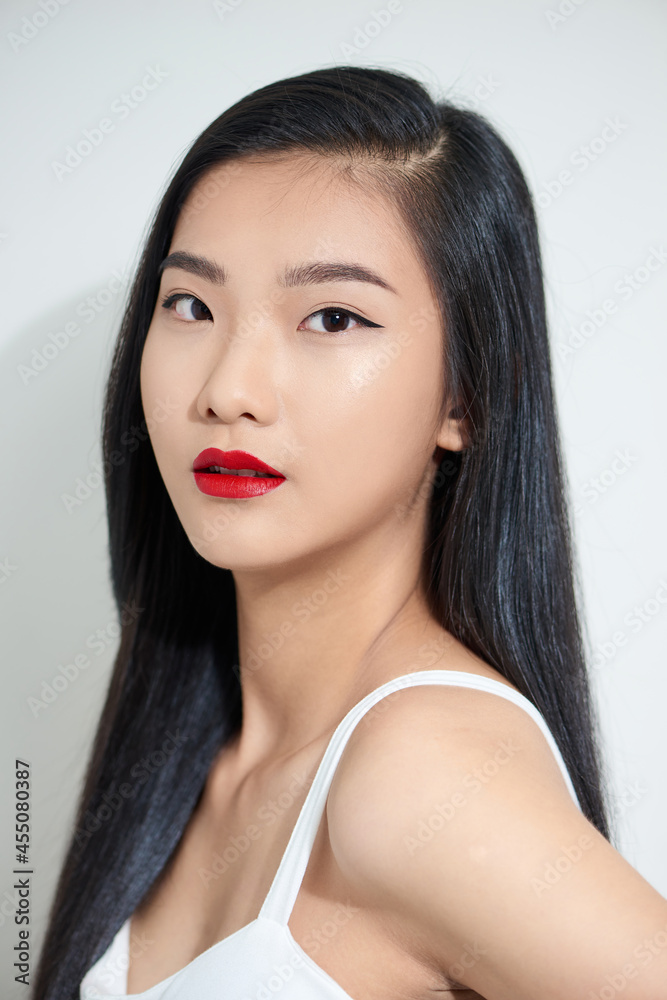 Closeup portrait of a young beautiful attractive asian woman feeling happily over a white background Closeup portrait of a young beautiful attractive asian woman feeling happily over a white background