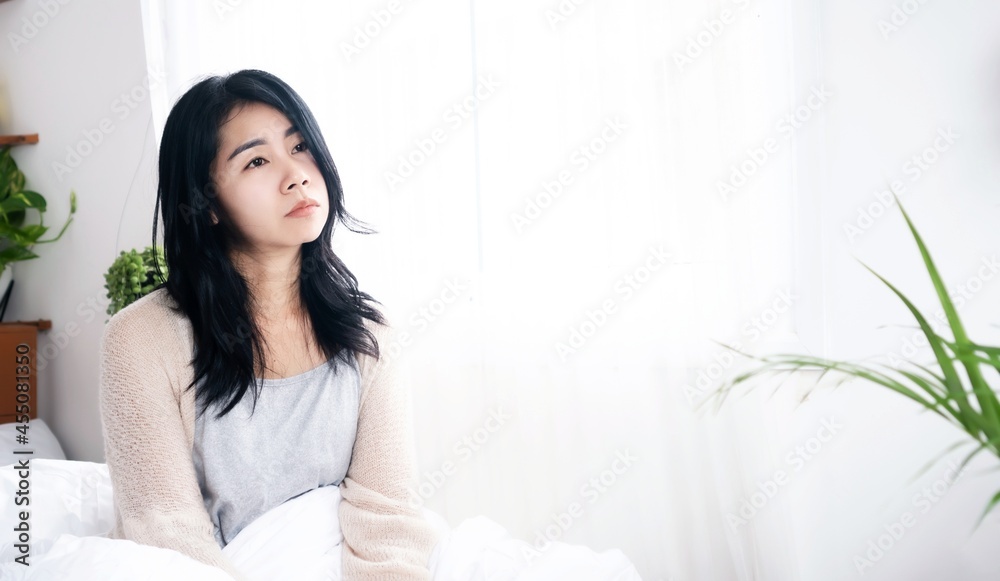 sad Asian woman in bed, worried, unhappy female thinking alone sad Asian woman in bed, worried, unhappy female thinking alone