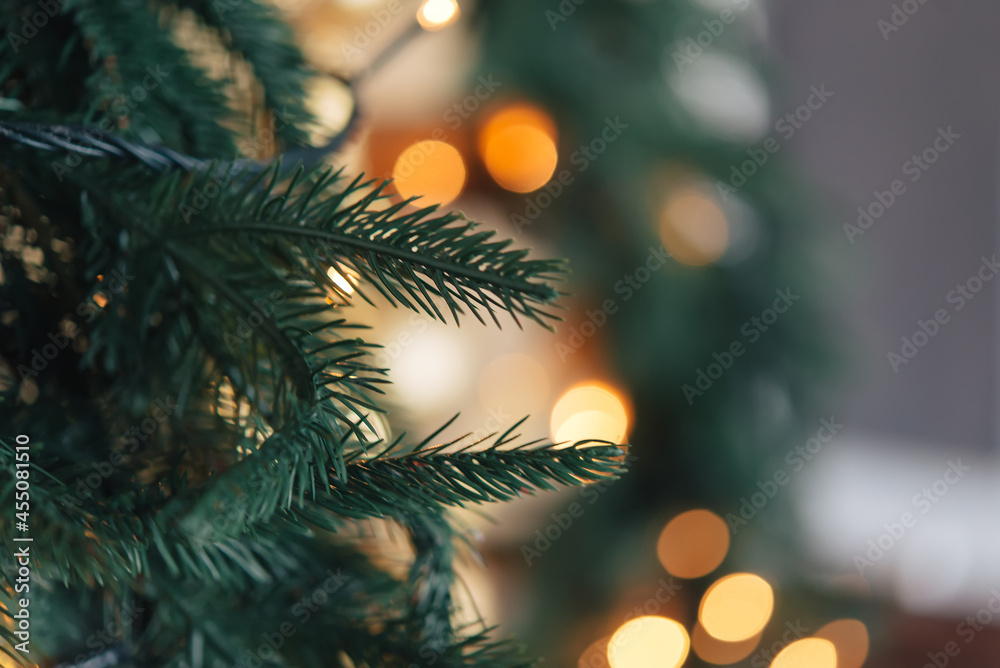 Christmas background, green pine branches festive background. Creative composition with border and copy space. New year decoration with bokeh lights from light bulbs