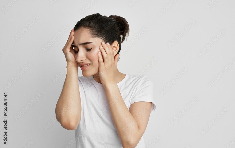 brunette in a white t-shirt holding her head migraine stress depression brunette in a white t-shirt holding her head migraine stress depression