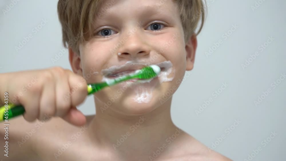 cheerful little boy brushing teeth in front of the bathroom mirror cheerful little boy brushing teeth in front of the bathroom mirror