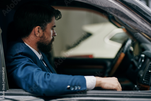 bearded man in a car suit driving around the city © SHOTPRIME STUDIO