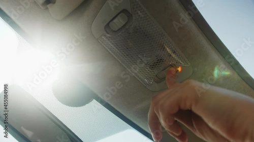 Person presses the button to close the sunroof in the car, close up. photo
