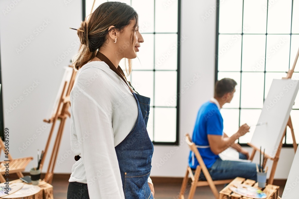 Young hispanic couple at art studio looking to side, relax profile pose with natural face with confident smile. Young hispanic couple at art studio looking to side, relax profile pose with natural face with confident smile.