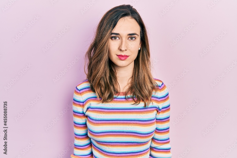 Young hispanic girl wearing casual clothes relaxed with serious expression on face. simple and natural looking at the camera. - obrazy, fototapety, plakaty 