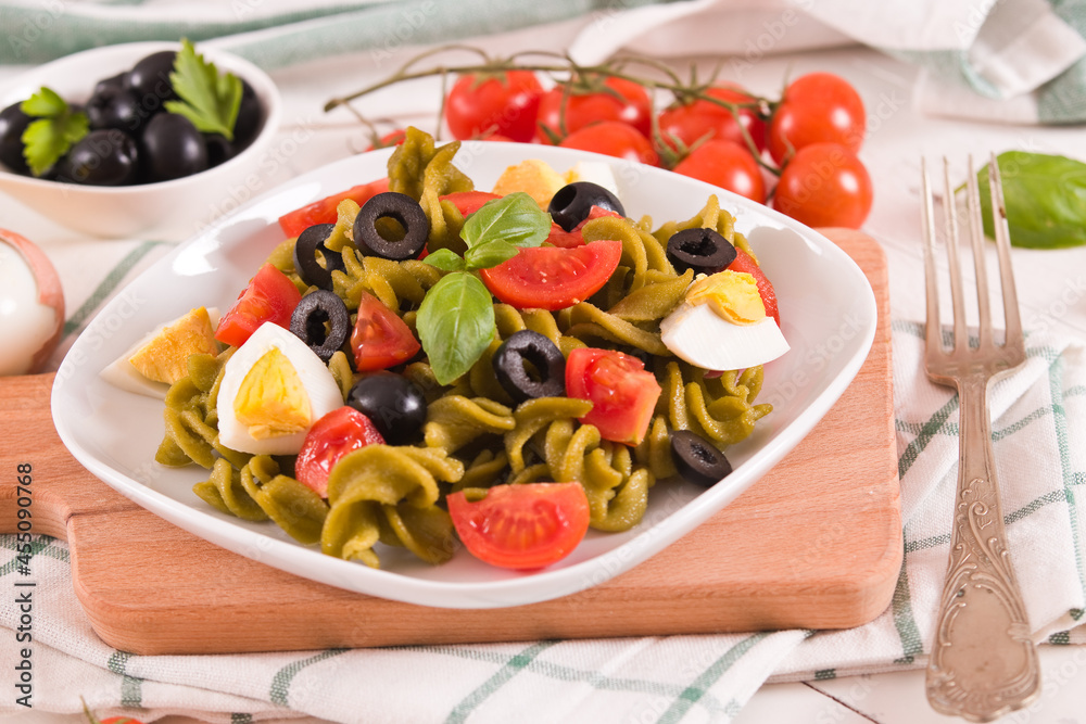 Fusilli pasta with cherry tomatoes, eggs and black olives.