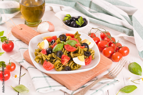 Fusilli pasta with cherry tomatoes  eggs and black olives.