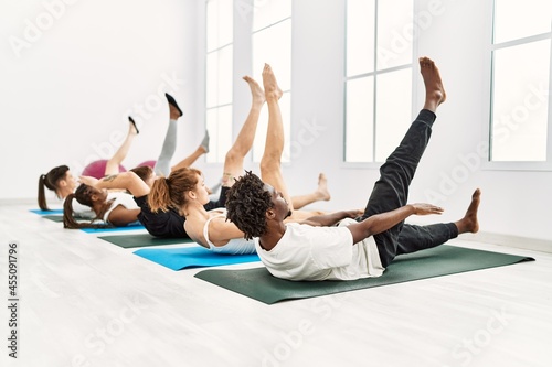 Group of young people concentrate stretching at sport center.