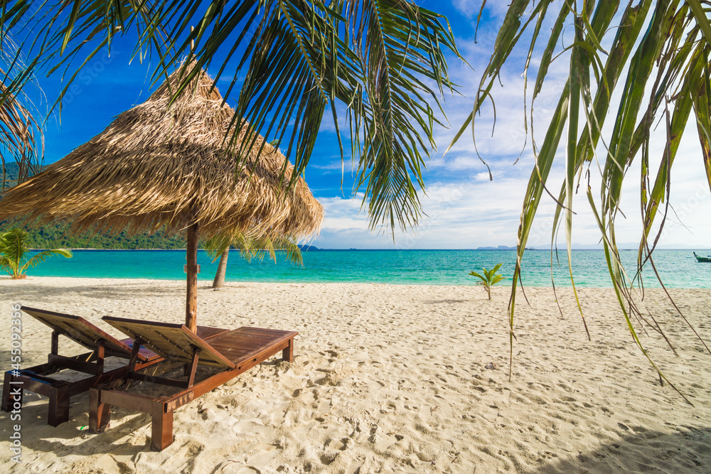 Wooden beach bench on white sand beach with coconut palm tree summer vacation
