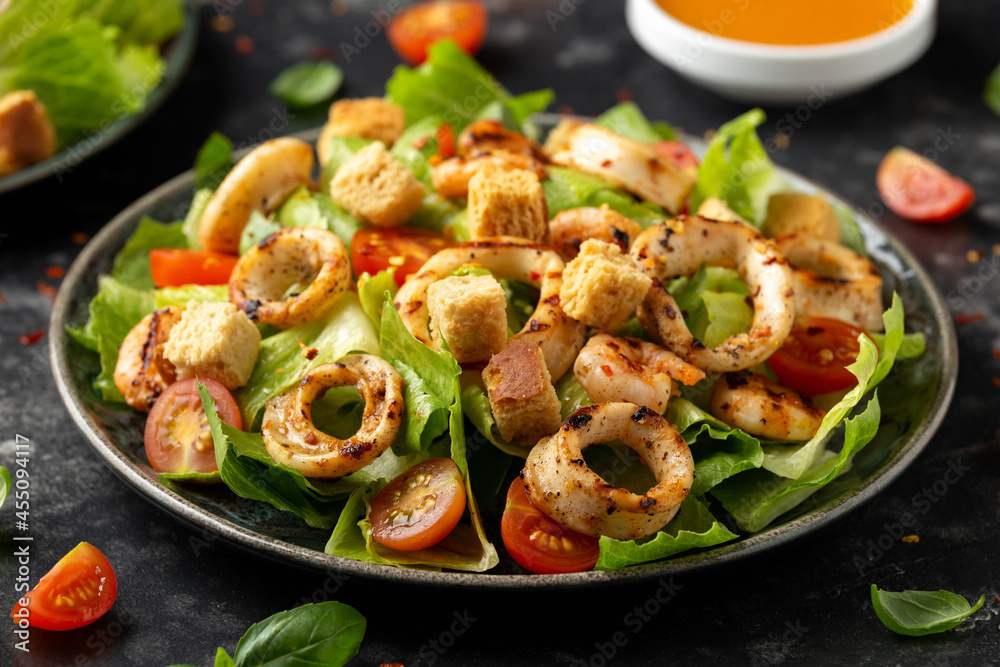 Grilled squid or calamari and shrimp salad with garlic croutons and cherry tomatoes. healthy food. Grilled squid or calamari and shrimp salad with garlic croutons and cherry tomatoes. healthy food.