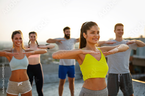 Fototapeta Naklejka Na Ścianę i Meble -  Group of happy fit friends exercising together outdoor
