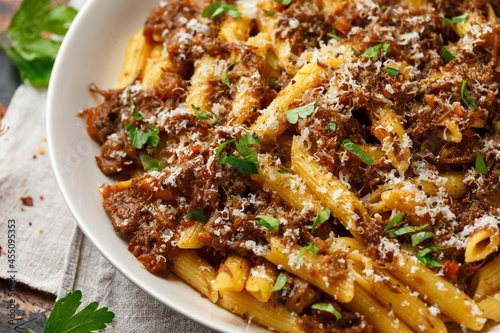 Pasta alla Genovese on a white bowl with parmesan cheese. Traditional neapolitan food.