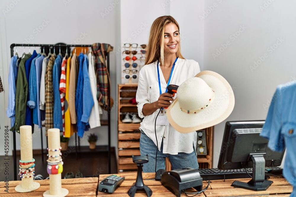 Young caucasian shopkeeper woman smiling happy working at clothing store.