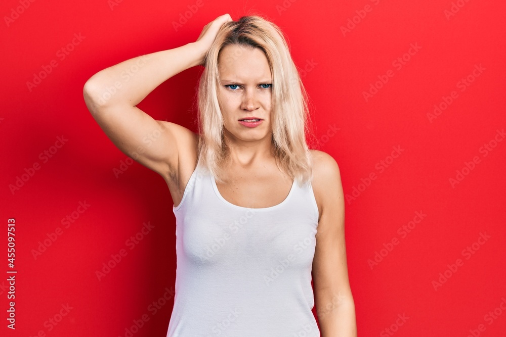 Beautiful caucasian blonde woman wearing casual white t shirt confuse and wonder about question. uncertain with doubt, thinking with hand on head. pensive concept. Beautiful caucasian blonde woman wearing casual white t shirt confuse and wonder about question. uncertain with doubt, thinking with hand on head. pensive concept.