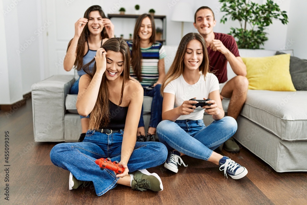 Group of young friends smiling happy playing video game at home. Group of young friends smiling happy playing video game at home.