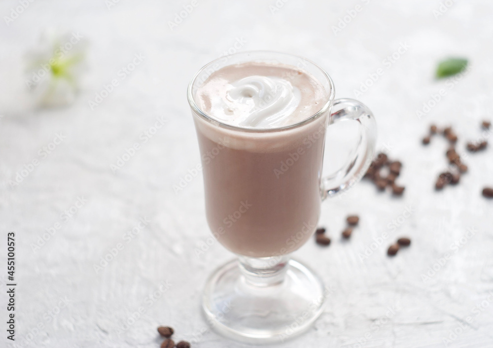 Warm cocoa in a glass goblet, behind chocolate chips and mint leaves. Top cream Warm cocoa in a glass goblet, behind chocolate chips and mint leaves. Top cream