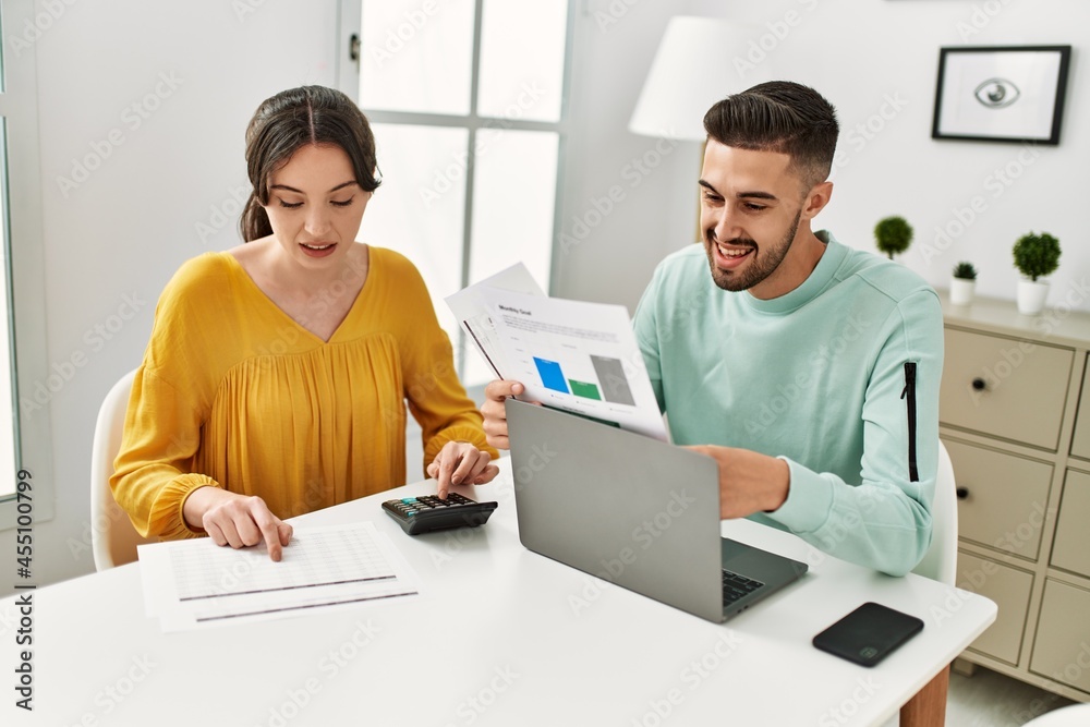 Young couple controlling family economy at home. Young couple controlling family economy at home.