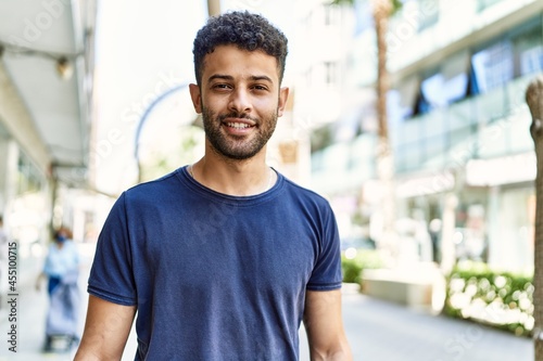 Young arab man smiling confident on a sunny day at the street