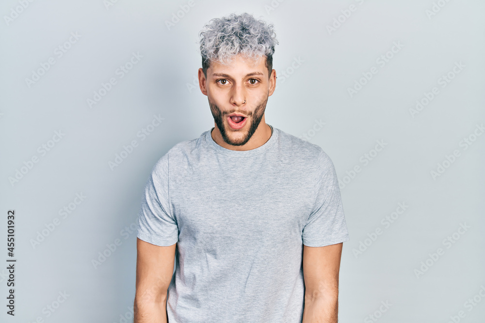Young hispanic man with modern dyed hair wearing casual grey t shirt afraid and shocked with surprise expression, fear and excited face. Young hispanic man with modern dyed hair wearing casual grey t shirt afraid and shocked with surprise expression, fear and excited face.