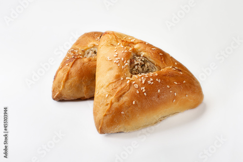 meat pies in the shape of a triangle on a white background. two meat pies