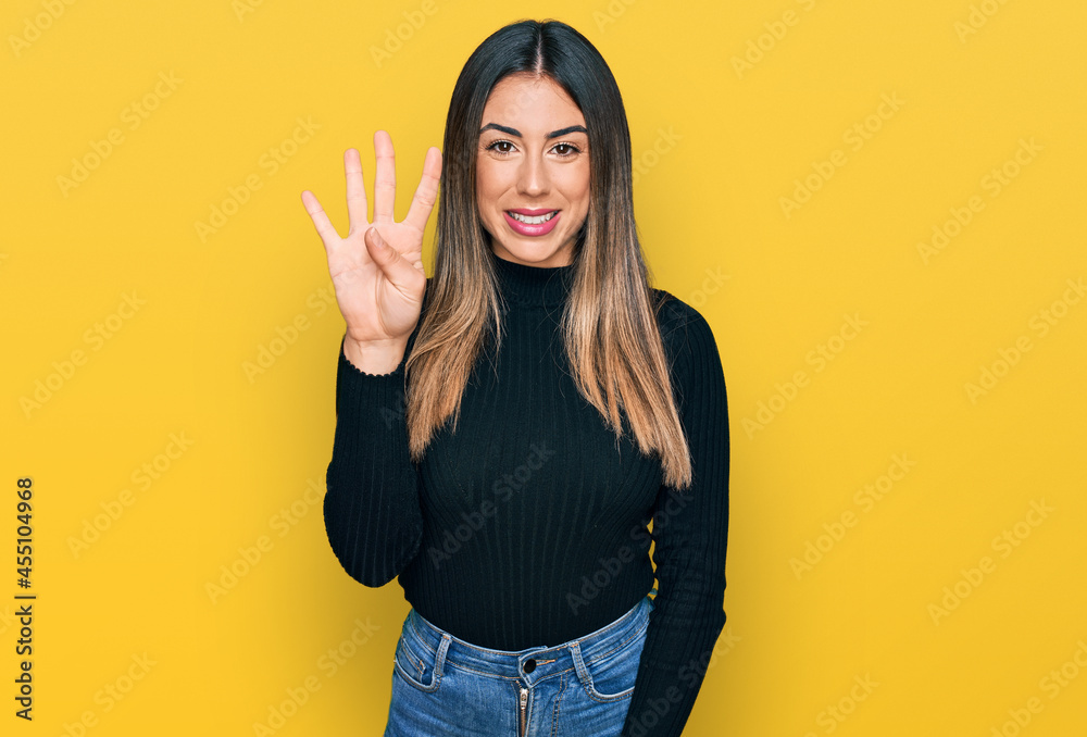 Young hispanic woman wearing casual clothes showing and pointing up with fingers number four while smiling confident and happy. Young hispanic woman wearing casual clothes showing and pointing up with fingers number four while smiling confident and happy.