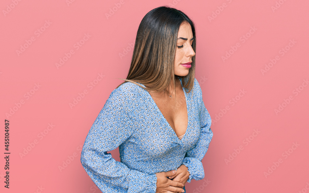Young hispanic woman wearing casual clothes with hand on stomach because indigestion, painful illness feeling unwell. ache concept. Young hispanic woman wearing casual clothes with hand on stomach because indigestion, painful illness feeling unwell. ache concept.