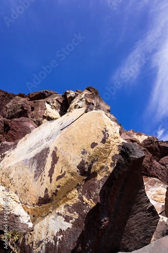 Huge red and yellow rock cliff on red sand beach Santorini. Alien landscape. © Anastasia
