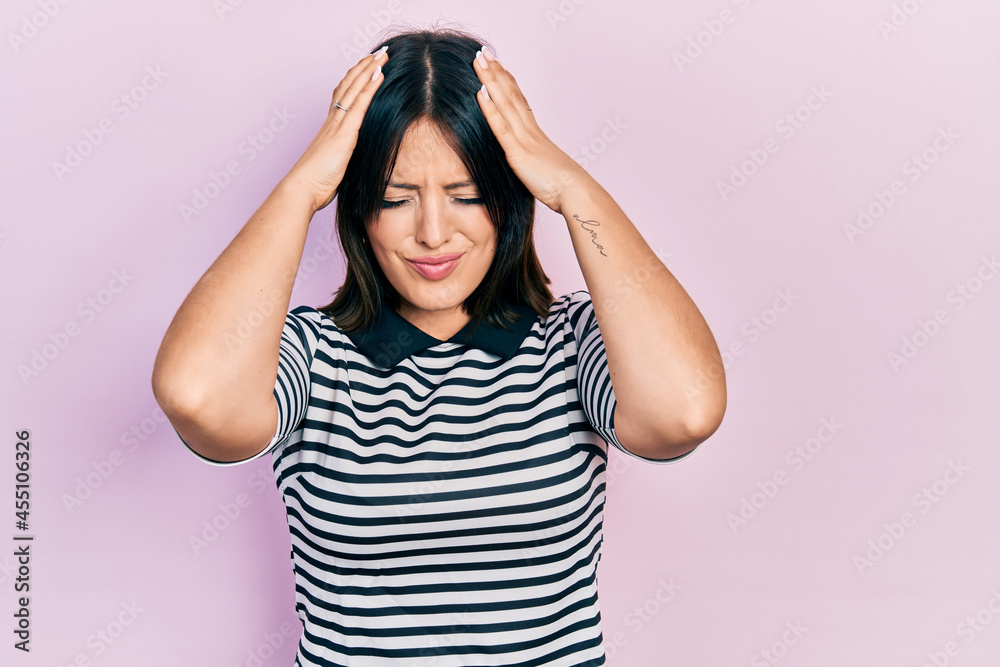 Young hispanic woman wearing casual clothes suffering from headache desperate and stressed because pain and migraine. hands on head. Young hispanic woman wearing casual clothes suffering from headache desperate and stressed because pain and migraine. hands on head.