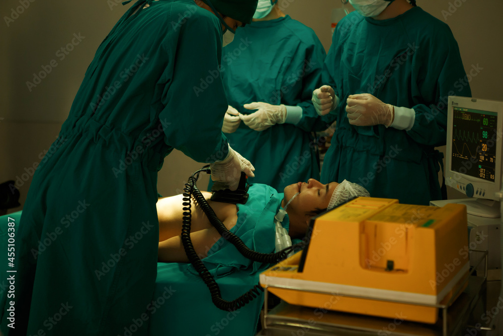 The medical team and nurses  defibrillating male patient in the operating room . group of surgeon work in surgery room