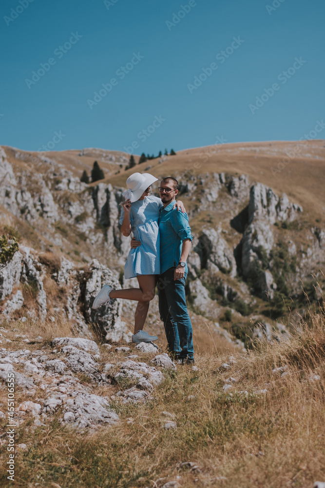 the loving couple are romantically posing against the background of the mountains