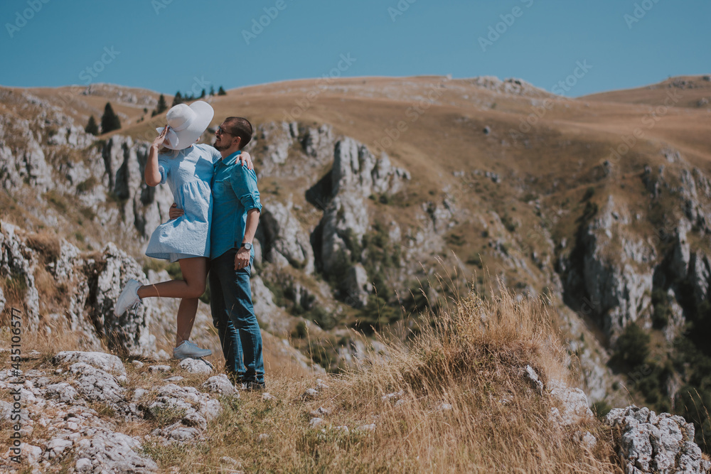 the loving couple are romantically posing against the background of the mountains