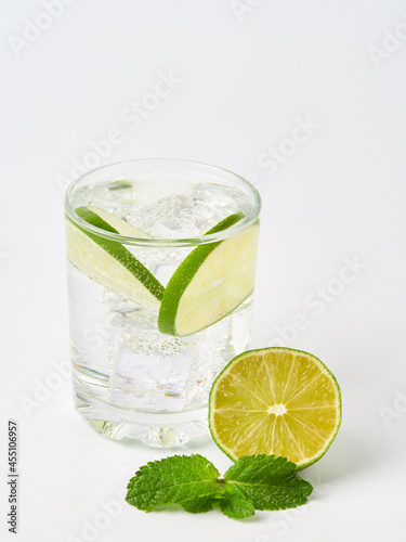 a glass of fresh drinking water and a lime. mineral water as a thirst quencher.