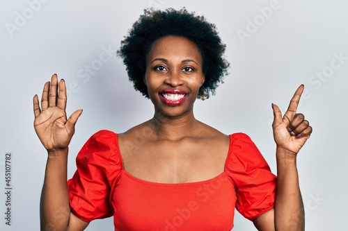 Young african american woman wearing casual clothes showing and pointing up with fingers number seven while smiling confident and happy.