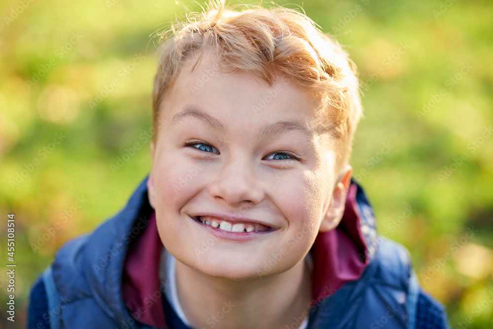 Close up of portrait little boy in blue jacket smiling on green background. Concept of happy child. Close up of portrait little boy in blue jacket smiling on green background. Concept of happy child.