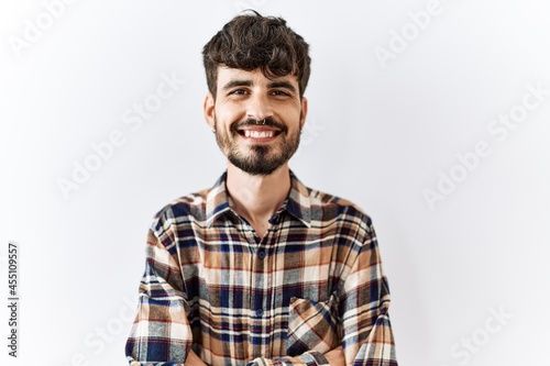 Hispanic man with beard standing over isolated background happy face smiling with crossed arms looking at the camera. positive person.