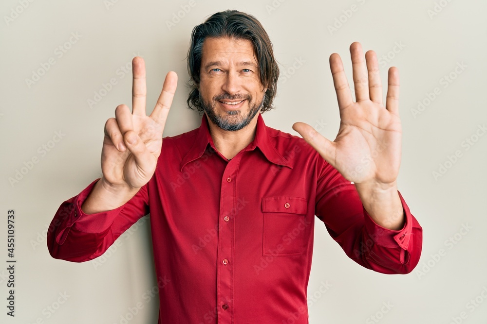 Middle age handsome man wearing casual clothes showing and pointing up with fingers number seven while smiling confident and happy.
