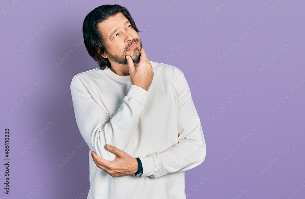 Middle age caucasian man wearing casual clothes with hand on chin thinking about question, pensive expression. smiling with thoughtful face. doubt concept. Middle age caucasian man wearing casual clothes with hand on chin thinking about question, pensive expression. smiling with thoughtful face. doubt concept.